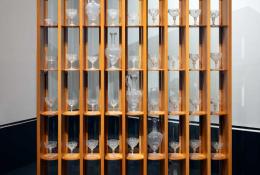 Martin Szekely (Paris FR, 1956), Backlit Display Case, Unique piece, Paris, 1996, Cedarwood and curved glass, h 228 × 149 × 41 cm.  Images with:  Carlo Tosi Caramea (Venice IT, 1929 – Venice IT, 2025), Quadrifoglio set 1950s, Venice, Hand-blown filigrana glass and gold leaf, based on XVIII century design, Blown by Maestro Caramea at Barovier & Toso furnace for SALIR, Murano.